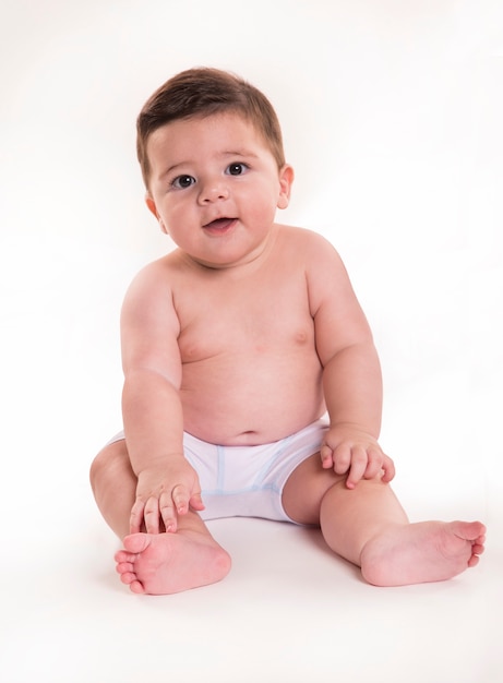 Niño pequeño sentado y mirando a cámara. Bebé brasileño.