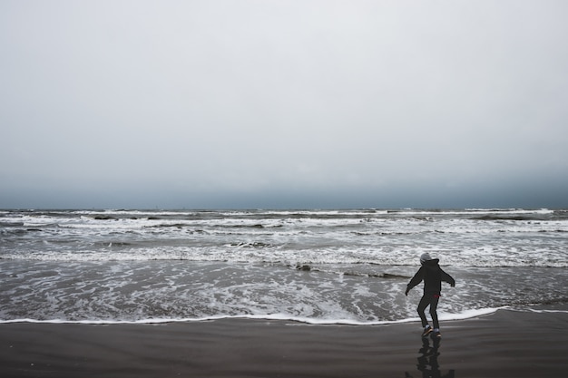 Un niño pequeño solo junto al océano