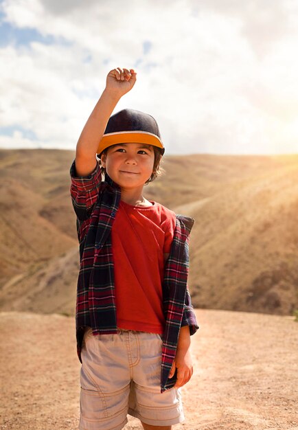 Niño pequeño con un sombrero en el fondo de las montañas al atardecer