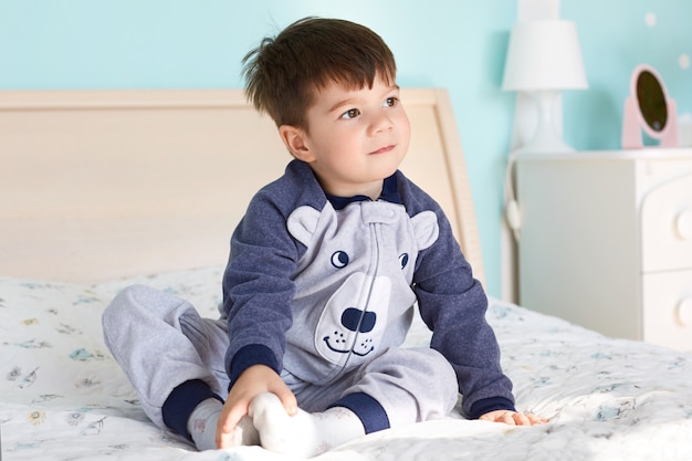 Niño pequeño soñador con cabello oscuro, apariencia agradable