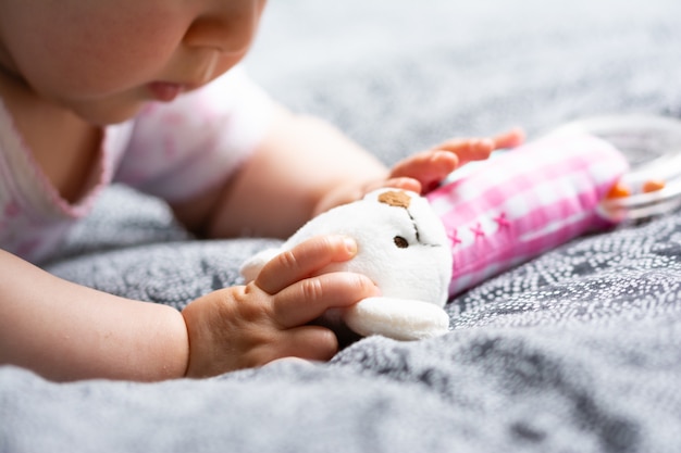 Un niño pequeño sostiene en su mano su juguete favorito, un sonajero, un bebé feliz.