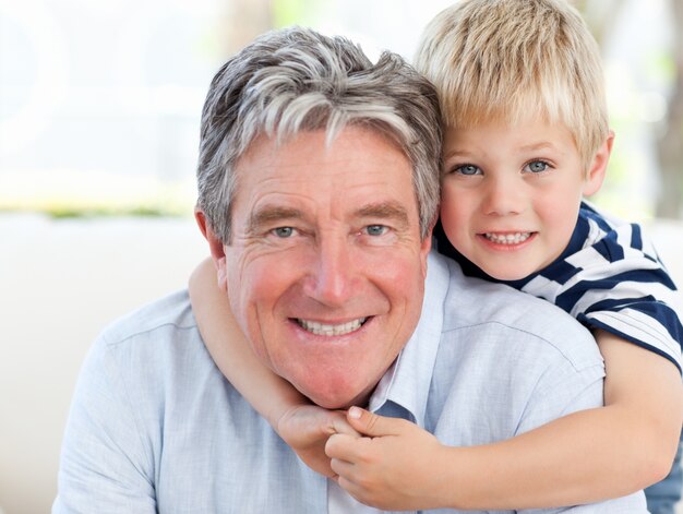 Niño pequeño con su abuelo mirando a la cámara