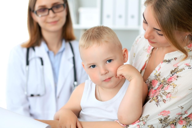 Niño pequeño con su madre después de un examen de salud en el consultorio del médico