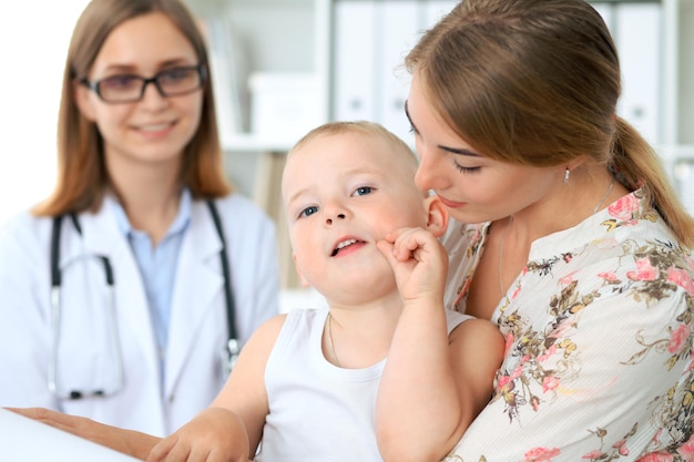 Niño pequeño con su madre después de un examen de salud en el consultorio del médico