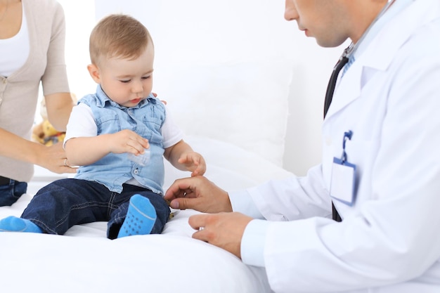 Niño pequeño con su madre en el examen de salud en el consultorio del médico