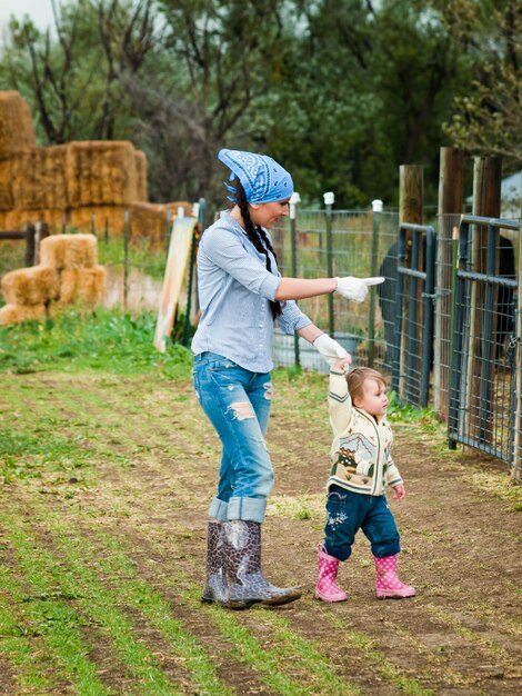 Niño pequeño con su mamá en la granja.