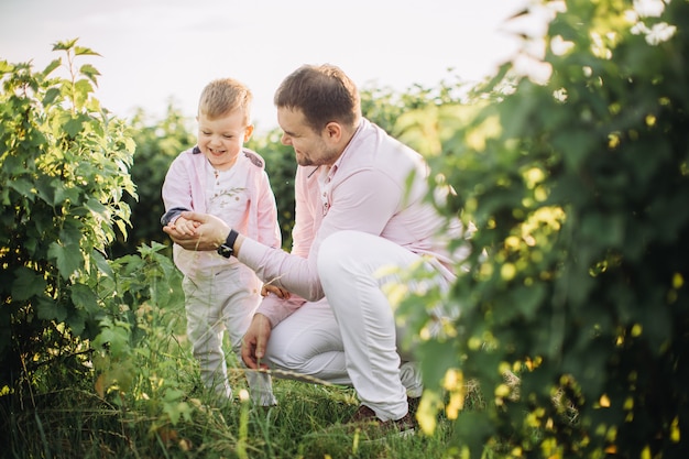 Niño pequeño con su padre en un campo verde