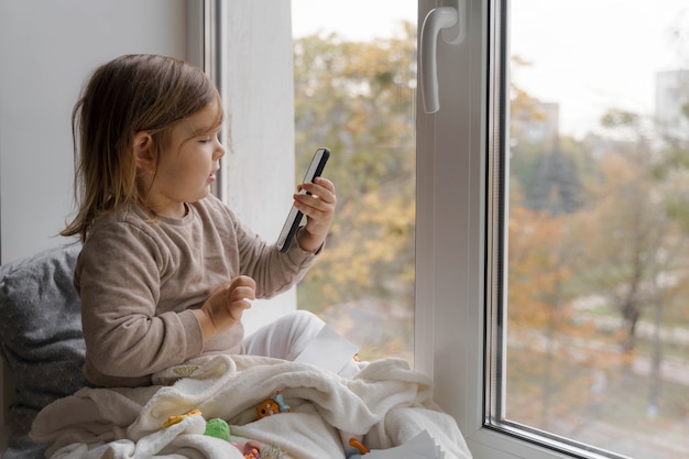 Niño pequeño con teléfono en casa