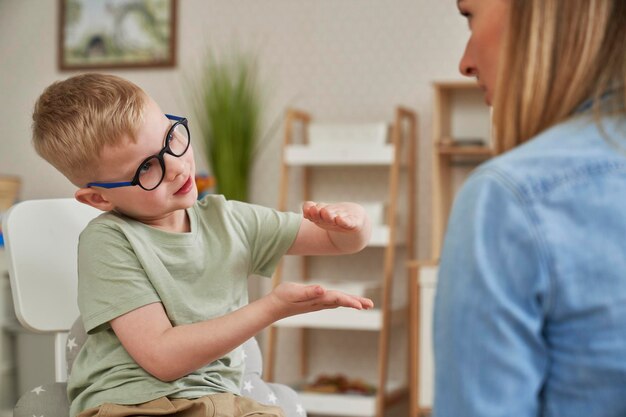 Foto niño pequeño y terapeuta en el aula