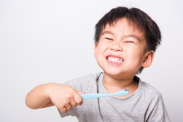 Niño pequeño tiene cepillo de dientes