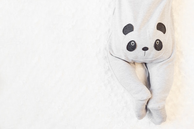 Niño pequeño en un traje de panda se encuentra en la cama.