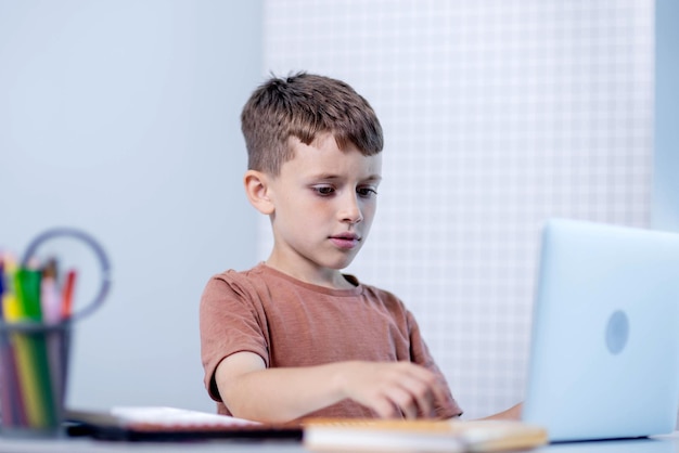 Niño pequeño usando portátil para la tarea Educación a distancia