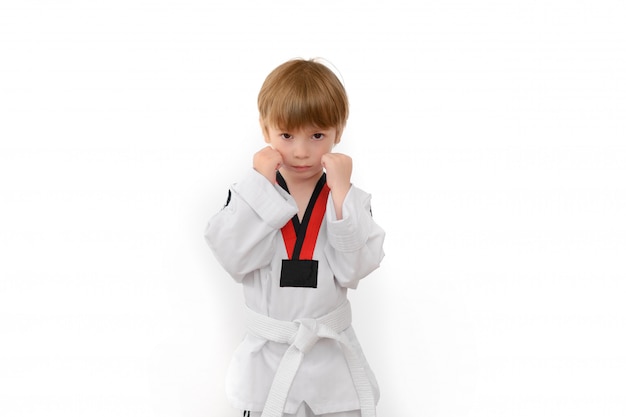 Niño pequeño vestido de dobok en blanco