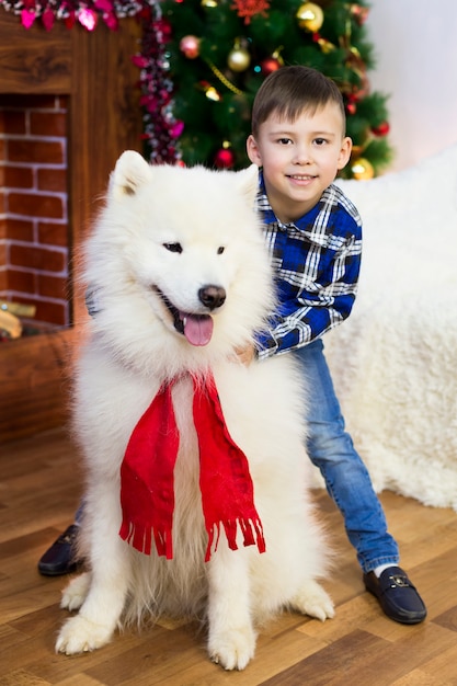 Un niño con un perro grande en Navidad.