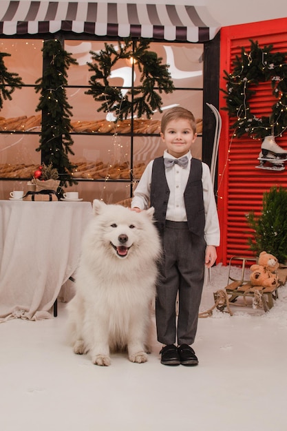 Niño con perro Samoyedo. Concepto de año nuevo