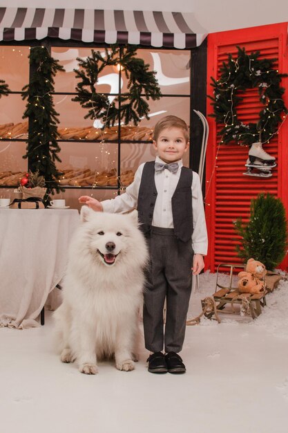 Niño con perro Samoyedo. Concepto de año nuevo