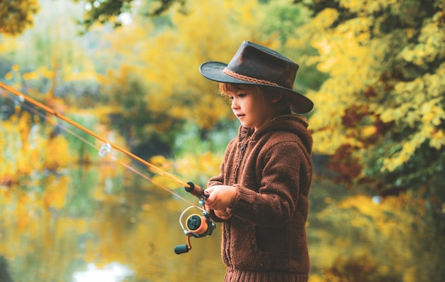 Niño pescando en el lago de otoño