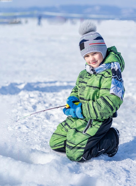 Niño pescando peces en el hielo