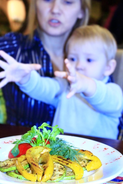 el niño le pide a su madre un plato para vegetarianos verduras a la parrilla pimentón tomates calabacín y hinojo