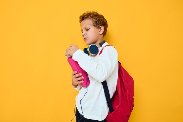 Foto niño de pie contra un fondo amarillo