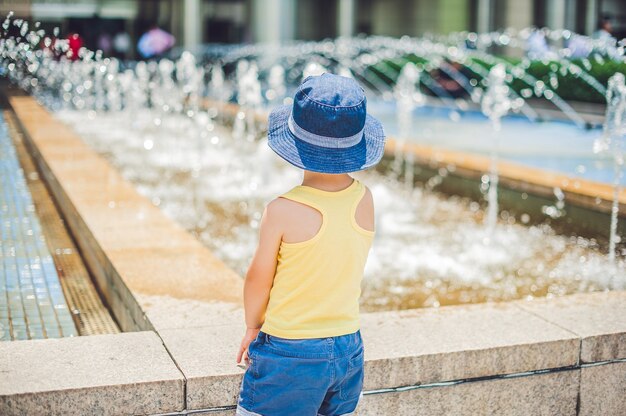 Niño de pie y mirando la fuente