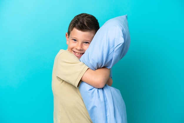 Niño en pijama aislado sobre fondo azul.