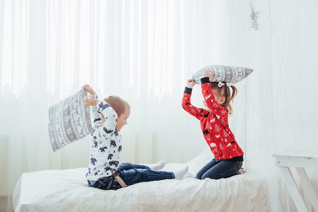 Niño en pijama suave y cálido jugando en la cama