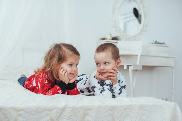 Niño en pijama suave y cálido jugando en la cama