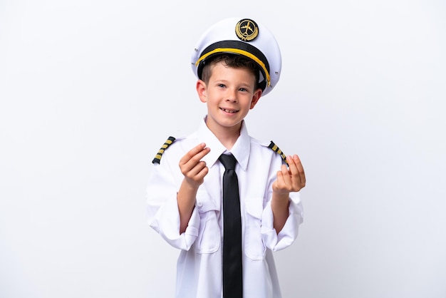 Foto niño piloto de avión aislado sobre fondo blanco haciendo gesto de dinero