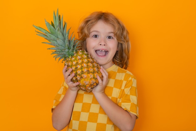 Niño de piña con piña en estudio Retrato de estudio de niño lindo sostener piña aislado sobre fondo amarillo