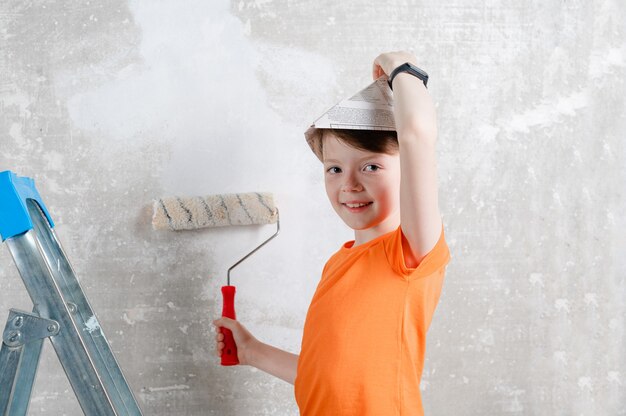 niño pinta las paredes con un cojín en la habitación Renovación familiar Casa Reparación y renovación del hogar