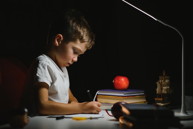 Niño pintando en una habitación oscura a última hora de la noche