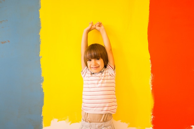 Niño pintando la pared del hogar en colores
