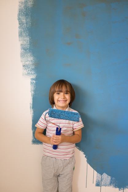 Foto niño pintando la pared del hogar en colores