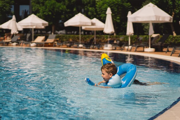 Foto un niño en una piscina en un día soleado