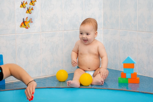 niño en la piscina jugando con juguetes en cubos coloridos