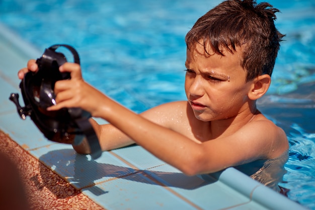 Niño en la piscina lleva una máscara