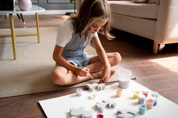 Niño en el piso de pintura de tiro completo