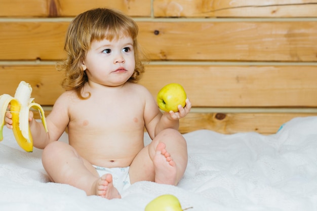 niño con plátano y manzanas