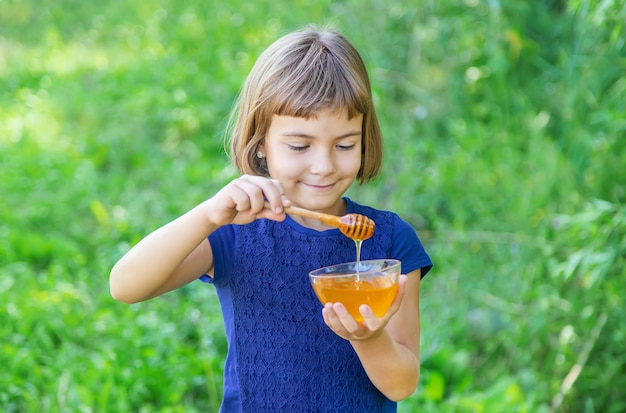 Niño un plato de miel en las manos