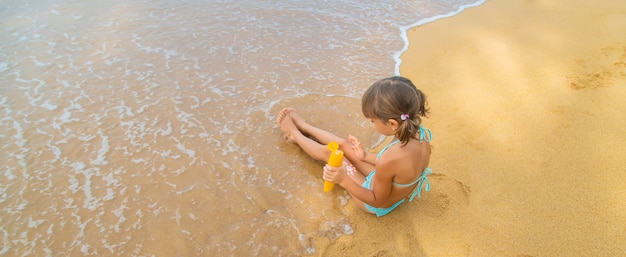 Niño en la playa con protector solar