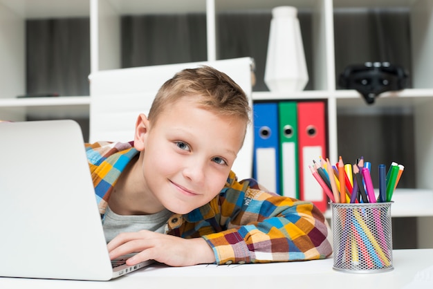 Foto niño con portátil en escritorio