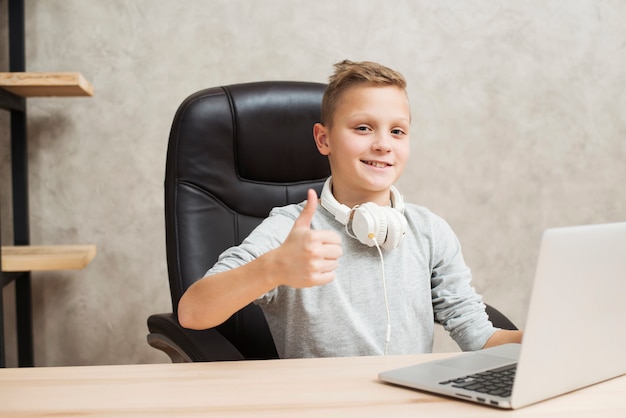 Niño con portátil en oficina