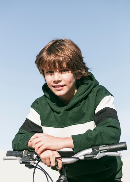 Niño posando sentado en su bicicleta