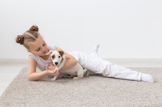 Niño posando en el suelo con cachorro