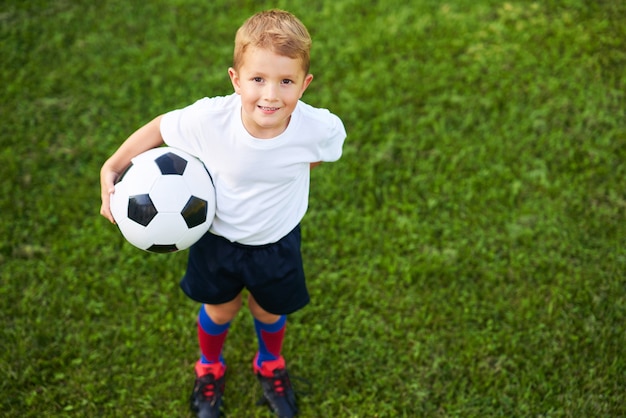 Niño practicando fútbol al aire libre