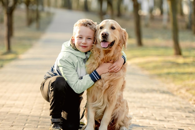 Niño preadolescente con perro golden retriever