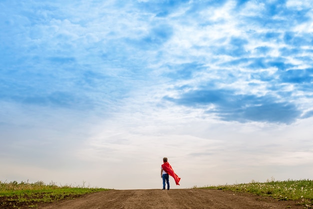 Foto niño preescolar, juega al superhéroe al aire libre