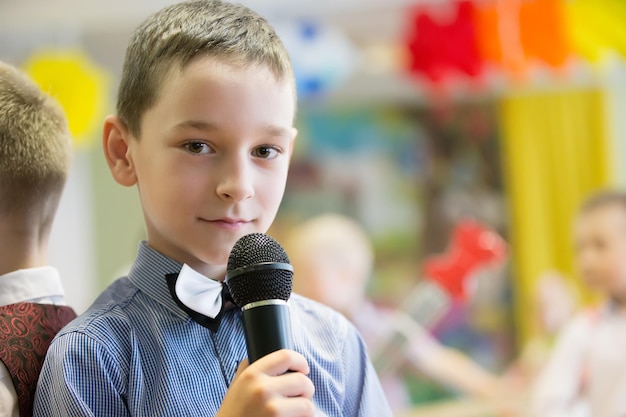 niño preescolar con micrófono un niño está cantando una canción