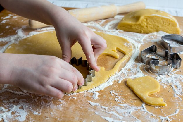 El niño prepara galletas caseras.